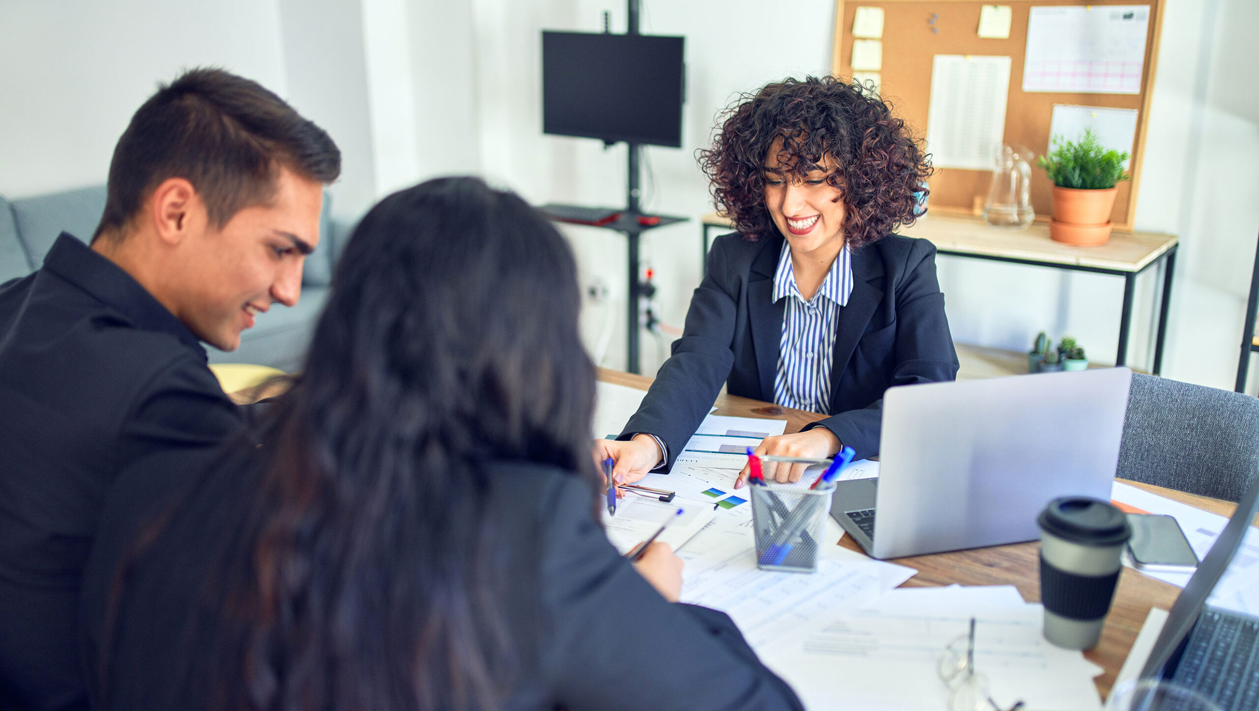 Three coworkers collaborating at a large table.